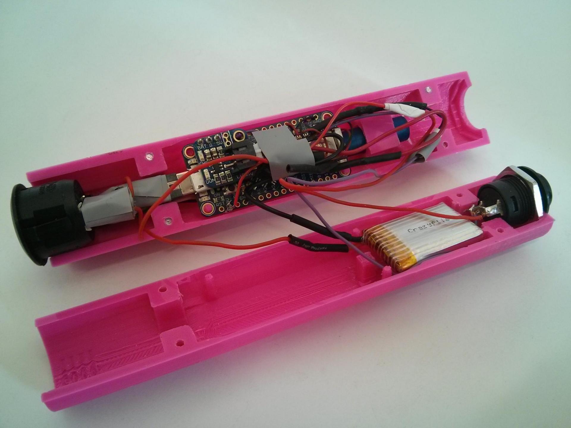 The intérieur of the final Vibrette prototype, showing the vibration motor, the arduino, buttons, and cables.